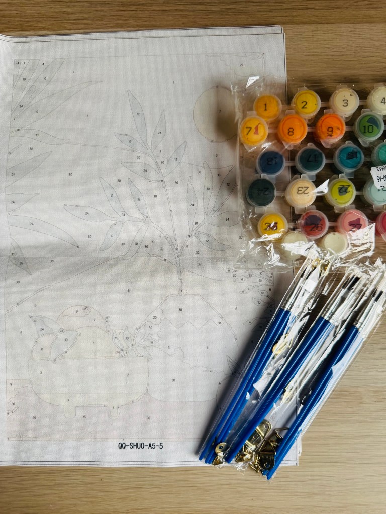 Canvas van schilderen op nummer met penselen en potjes verf