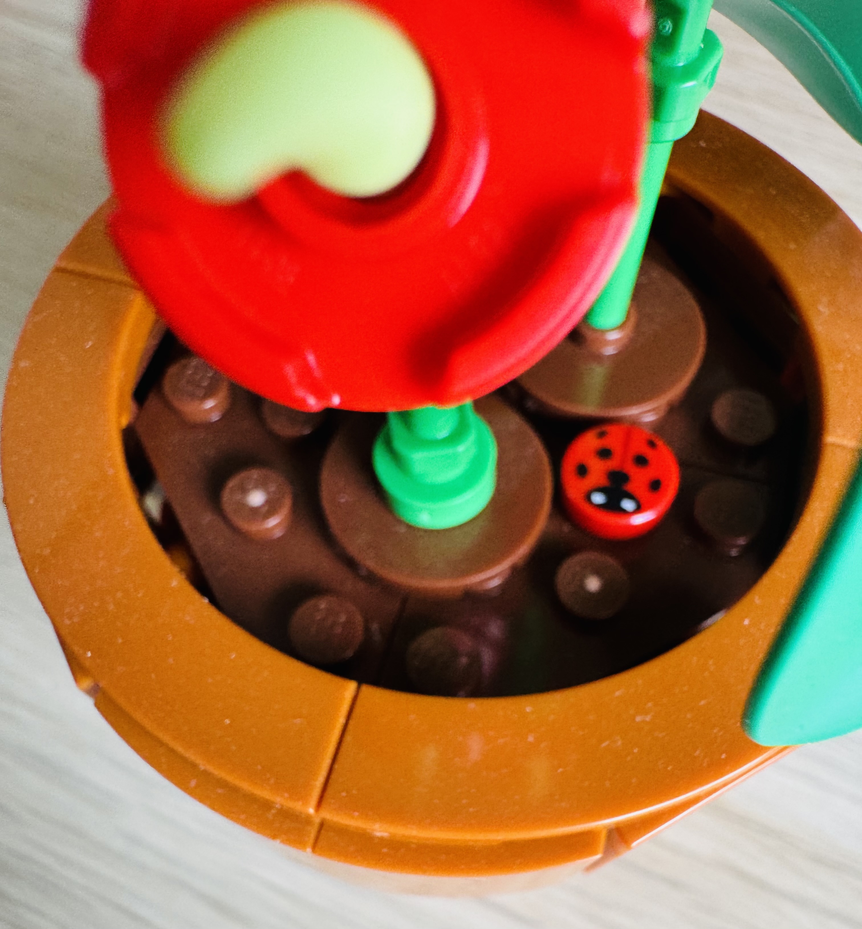 Close up van een LEGO mini plantje met een lieveheersbeestje erin