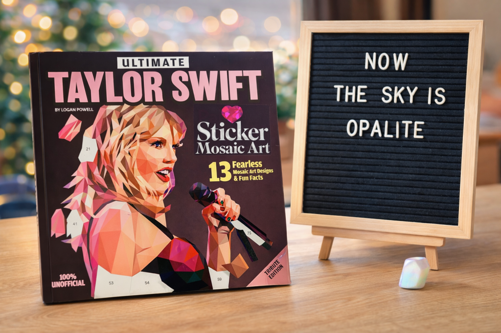 Stickerboek van Taylor Swift op een tafel naast een letterbord met ‘now the sky is opalite’