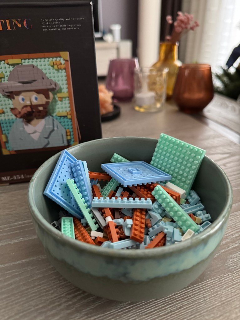 Een bakje met alle mini blokjes erin met daarachter het doosje van de set