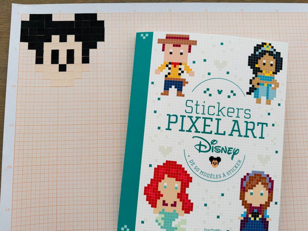 Het Pixelboek en pixel Mickey Mouse op rasterpapier