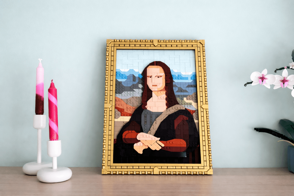 Lego Mona Lisa op een plank met daarnaast kaarsen en een Lego plant