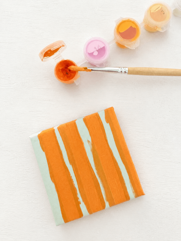 Het canvas met washi tape en verf en een kwast