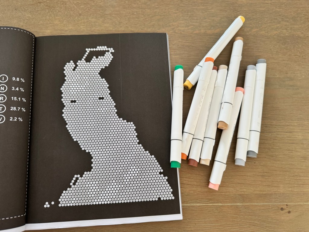Een pagina uit het kleurboek met alcoholmarkers ernaast