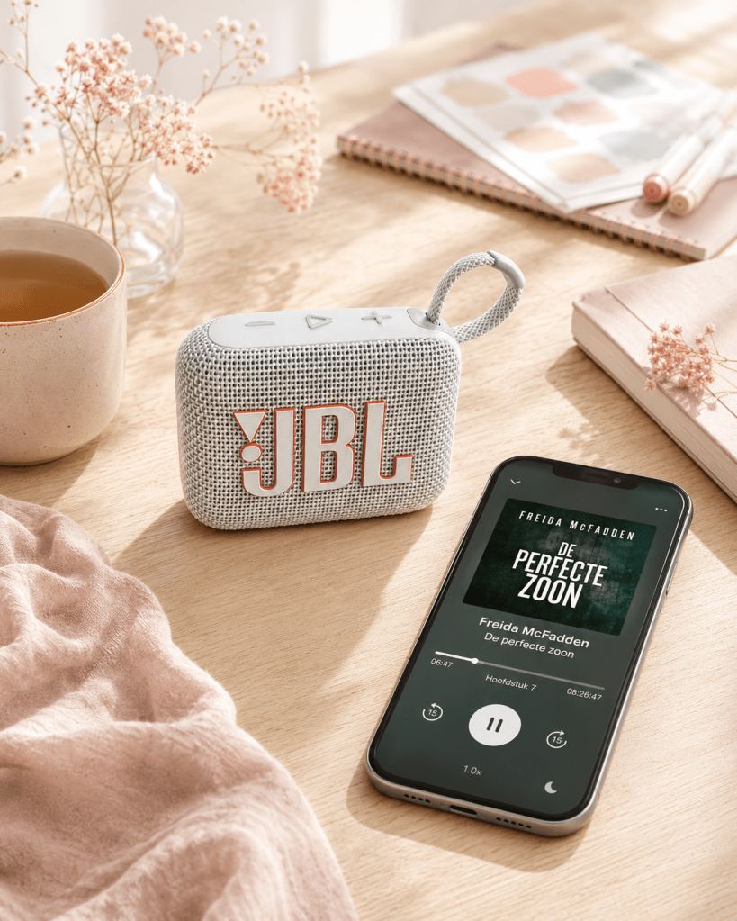 De JBL Go speaker naast een mobiele telefoon waarop een luisterboek wordt afgespeeld